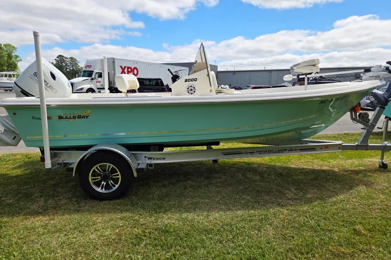 Slide: The Image of 2023 Bulls Bay 2000 boat on trailer, parked on grass under cloudy sky. - 6