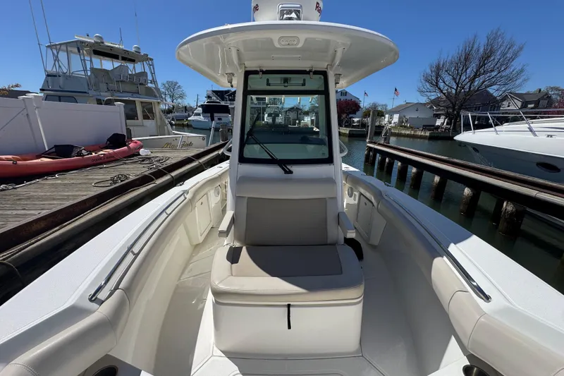Slide: The Image of 2017 Boston Whaler 250 Outrage boat docked at marina, showcasing spacious seating area. - 12