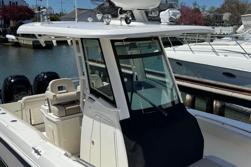 Slide: The Image of 2017 Boston Whaler 250 Outrage boat docked, featuring sleek design and dual engines. - 14