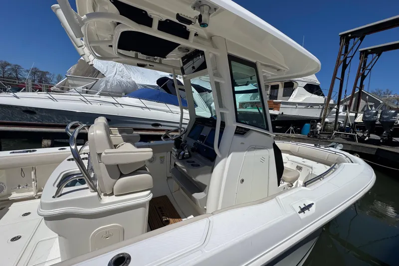 Slide: The Image of 2017 Boston Whaler 250 Outrage boat interior at marina, featuring helm and seating. - 2