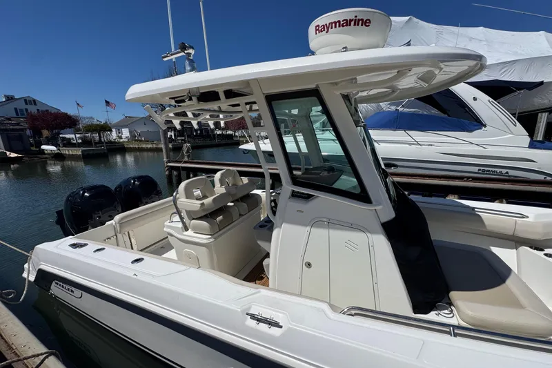 Slide: The Image of 2017 Boston Whaler 250 Outrage boat docked, featuring Raymarine equipment and dual engines. - 3
