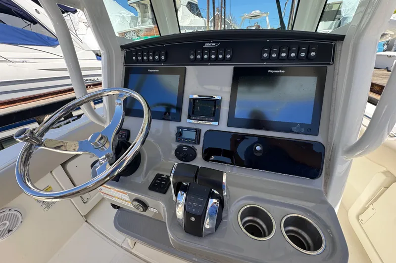 Slide: The Image of Boston Whaler 250 Outrage 2017 helm with dual Raymarine displays and stainless steel steering wheel. - 6