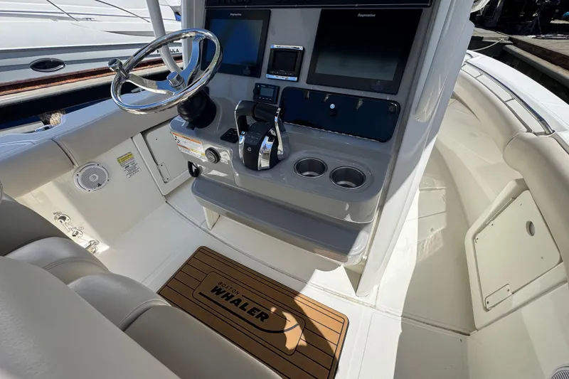 Slide: The Image of 2017 Boston Whaler 250 Outrage helm with steering wheel and navigation controls. - 9