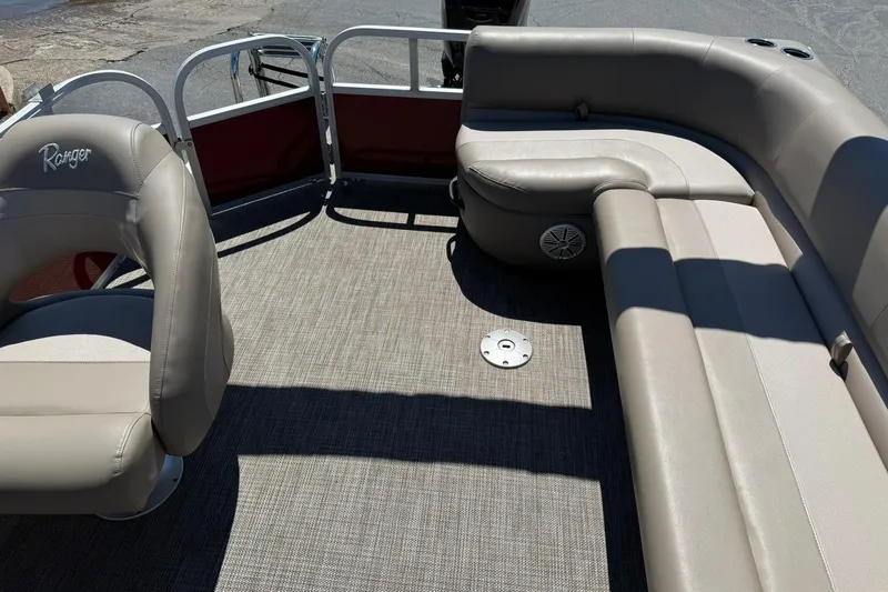 Slide: The Image of 2022 Ranger 200C pontoon boat interior with beige seating and carpeted flooring. - 12