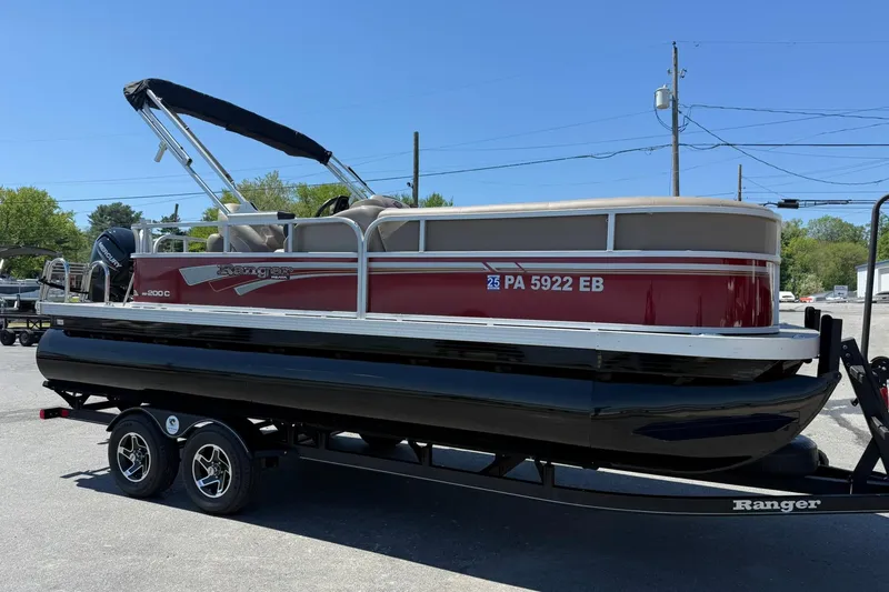 Slide: The Image of 2022 Ranger 200C pontoon boat with red exterior on a trailer in a parking lot. - 6