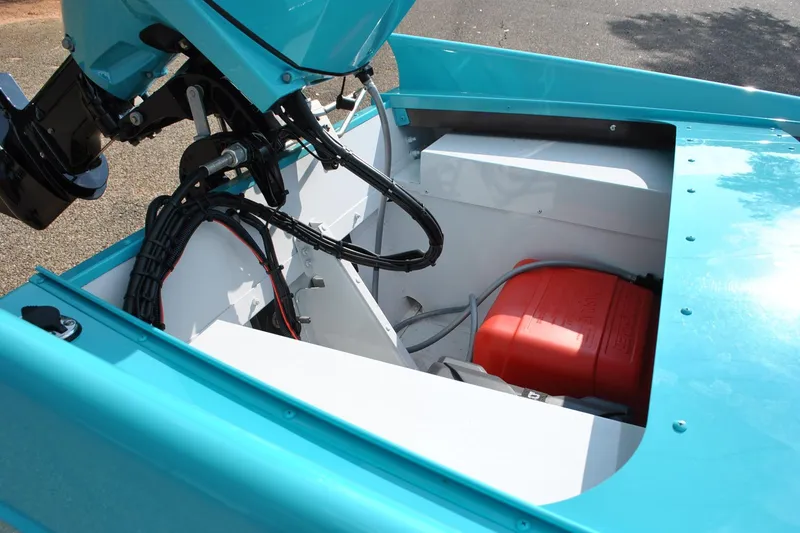 Slide: The Image of 2025 Starcraft 57 Ski Champ boat engine compartment with visible wiring and red fuel tank. - 12