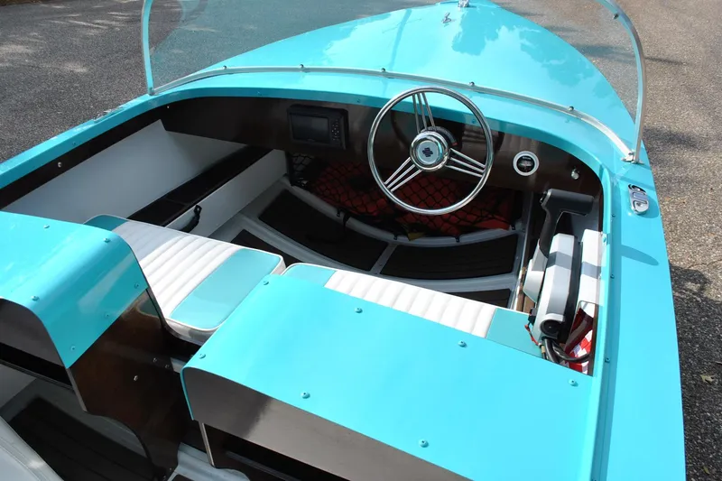 Slide: The Image of Turquoise 2025 Starcraft 57 Ski Champ boat interior with steering wheel and seating. - 9
