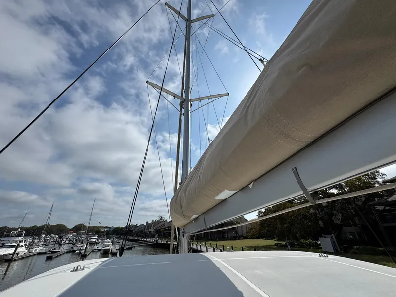 Slide: The Image of Lagoon 46 catamaran, 2022 model, docked at marina under a partly cloudy sky. - 21