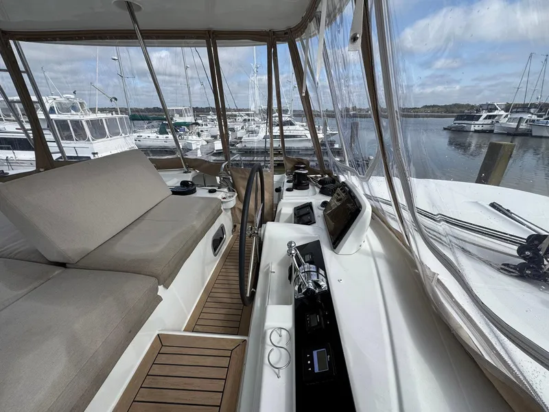 Slide: The Image of 2022 Lagoon 46 yacht interior with helm, seating, and marina view. - 26
