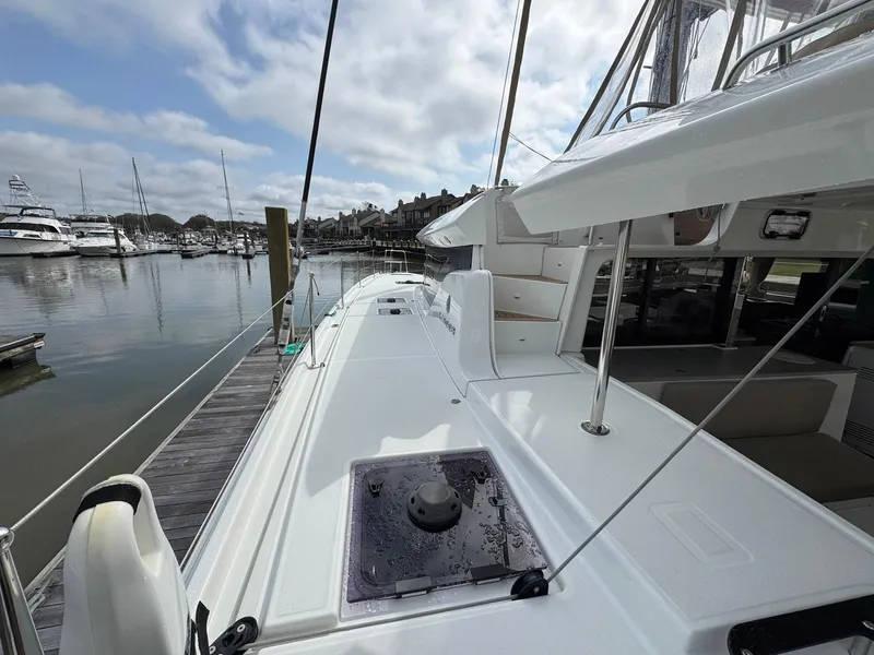 Slide: The Image of 2022 Lagoon 46 catamaran docked at marina, showcasing sleek deck design and spacious layout. - 32
