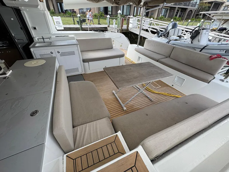 Slide: The Image of Spacious outdoor seating area on a 2022 Lagoon 46 catamaran, featuring comfortable cushions and a table. - 33