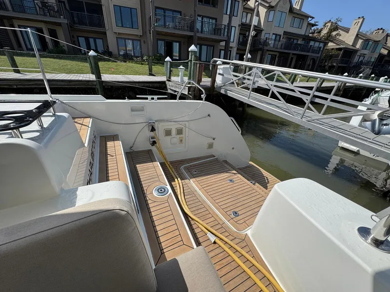 Slide: The Image of Stern view of 2022 Lagoon 46 catamaran docked at marina with wooden deck. - 36