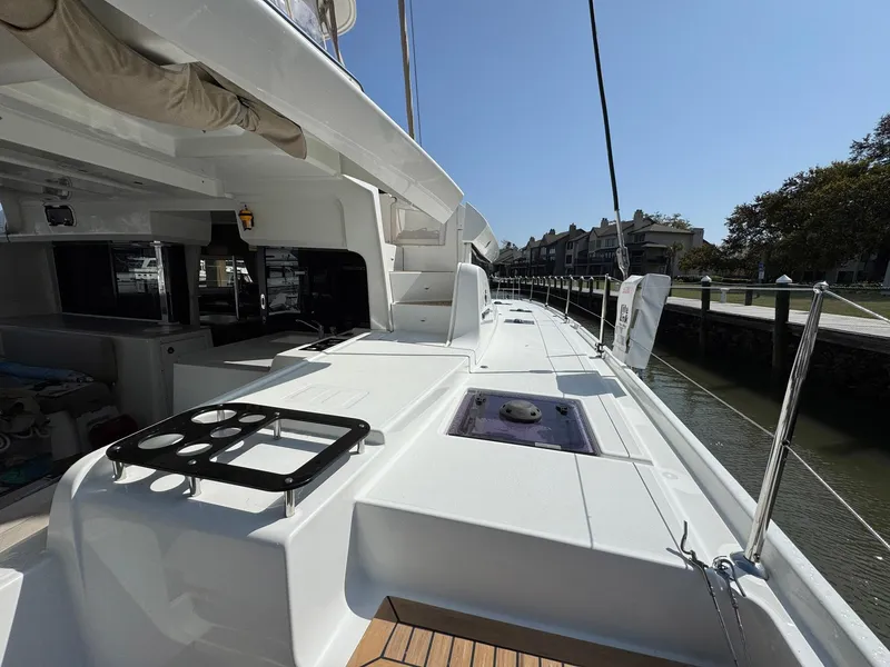 Slide: The Image of 2022 Lagoon 46 catamaran deck, featuring sleek design and spacious layout in marina setting. - 37