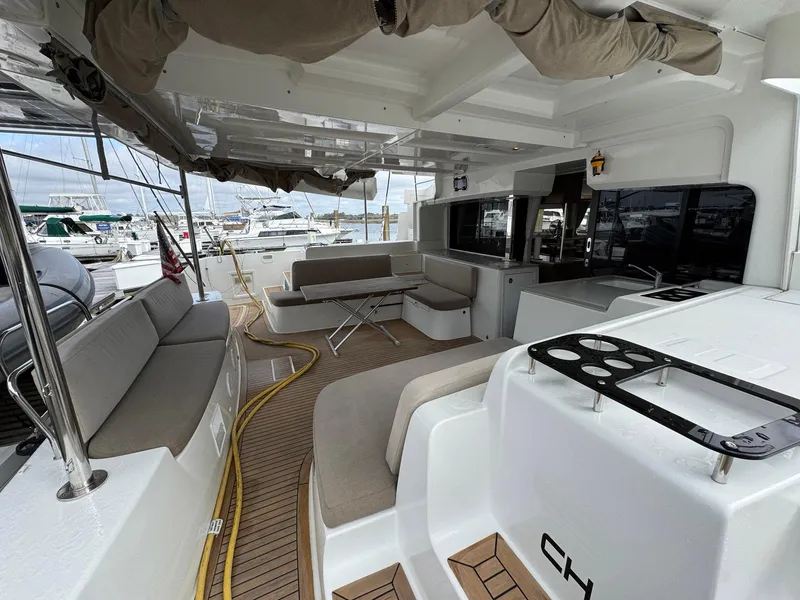 Slide: The Image of Spacious deck of 2022 Lagoon 46 catamaran with seating and marina view. - 40
