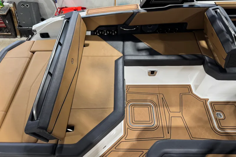 Slide: The Image of 2023 Cobalt R6 Surf boat interior with tan and black seating and detailed flooring. - 12