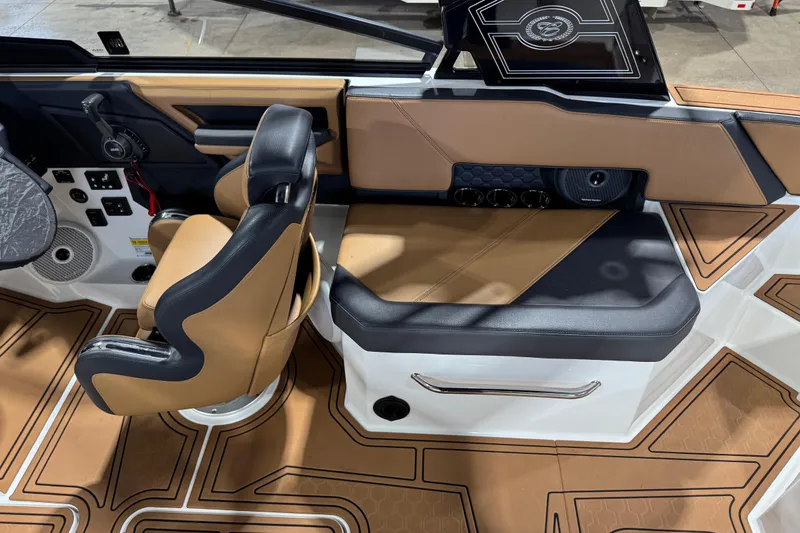 Slide: The Image of 2023 Cobalt R6 Surf boat interior with tan and black seating, modern dashboard, and stylish flooring. - 13