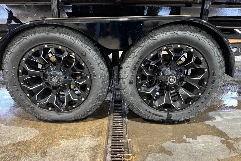 Slide: The Image of Black alloy wheels on a 2023 Cobalt R6 Surf trailer, wet concrete surface. - 5