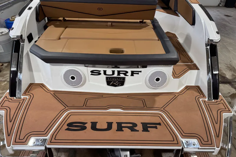 Slide: The Image of 2023 Cobalt R6 Surf boat with tan seating and custom deck design. - 9