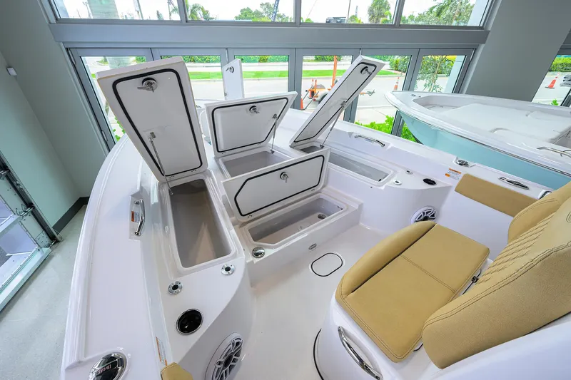 Slide: The Image of 2025 Sportsman Masters 267 Bay Boat interior with open storage compartments and beige seating. - 30