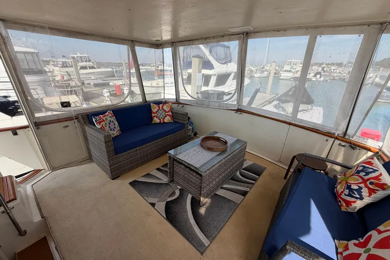 Slide: The Image of Enclosed deck of 1987 Viking 44 Motor Yacht with wicker seating and marina view. - 22