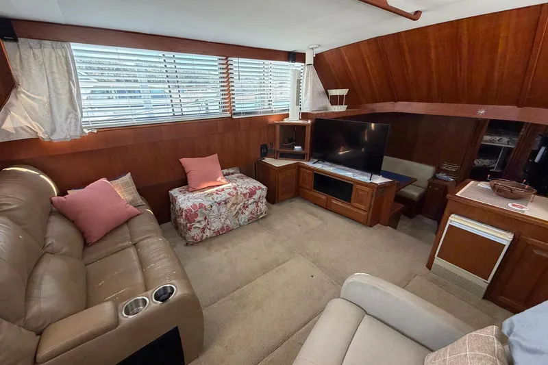 Slide: The Image of 1987 Viking 44 Motor Yacht interior with cozy seating, TV, and wood paneling. - 40