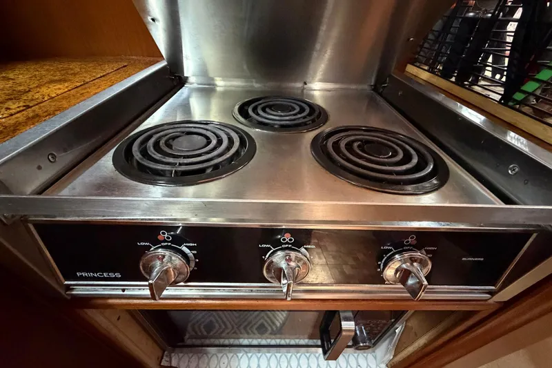 Slide: The Image of Electric stove in 1987 Viking 44 Motor Yacht kitchen, featuring three burners and control knobs. - 51