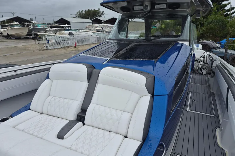 Slide: The Image of 2020 Nor-Tech 450 Sport Center Console with sleek blue and white seating, docked outdoors. - 14