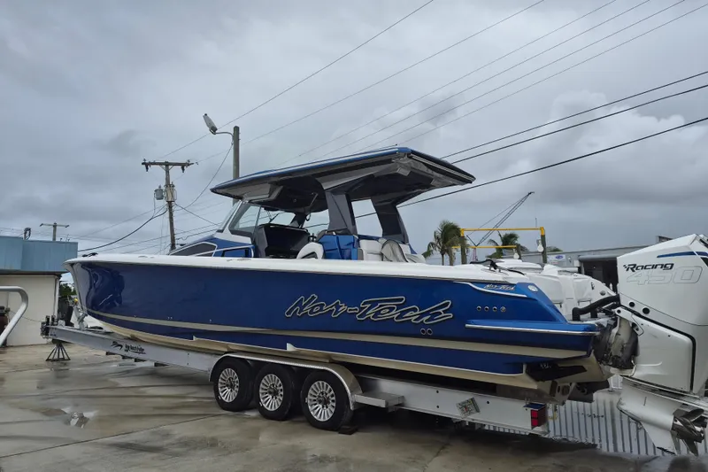 Slide: The Image of 2020 Nor-Tech 450 Sport Center Console boat on trailer, blue and white design. - 2