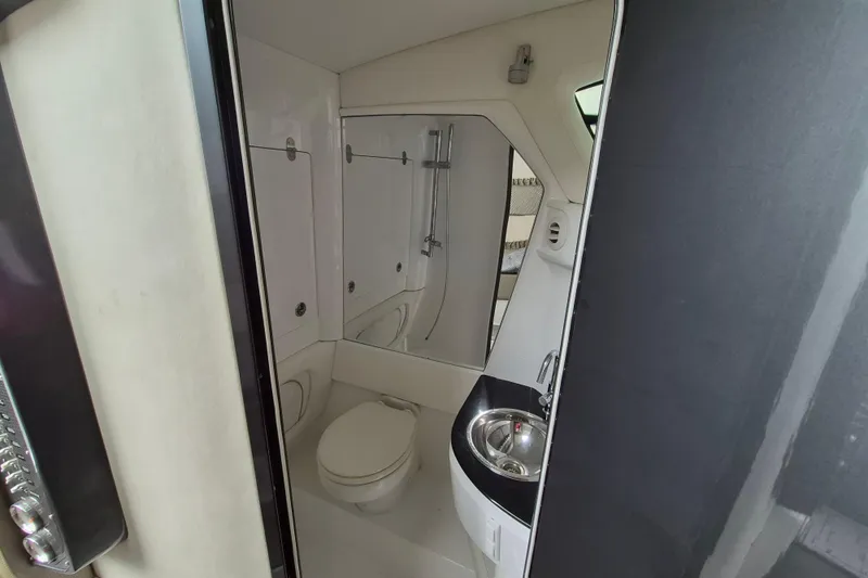 Slide: The Image of Interior of 2020 Nor-Tech 450 Sport Center Console boat bathroom with toilet and sink. - 20