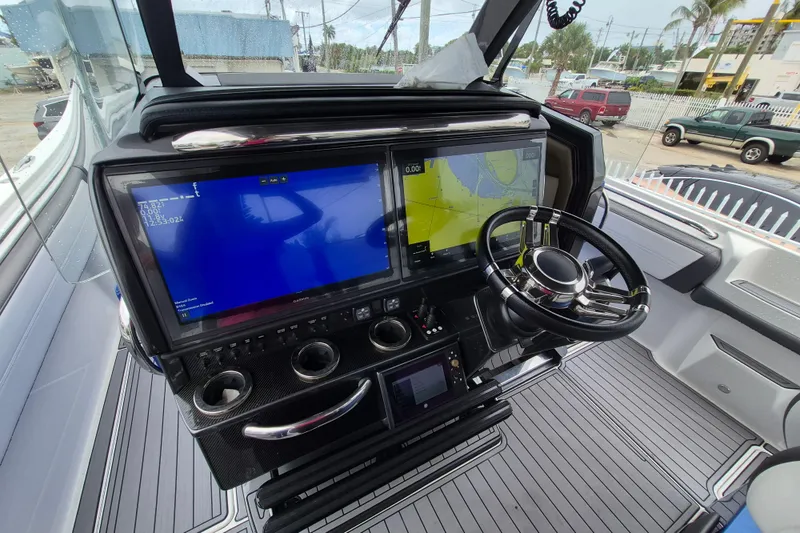 Slide: The Image of 2020 Nor-Tech 450 Sport Center Console helm with dual navigation screens and steering wheel. - 25