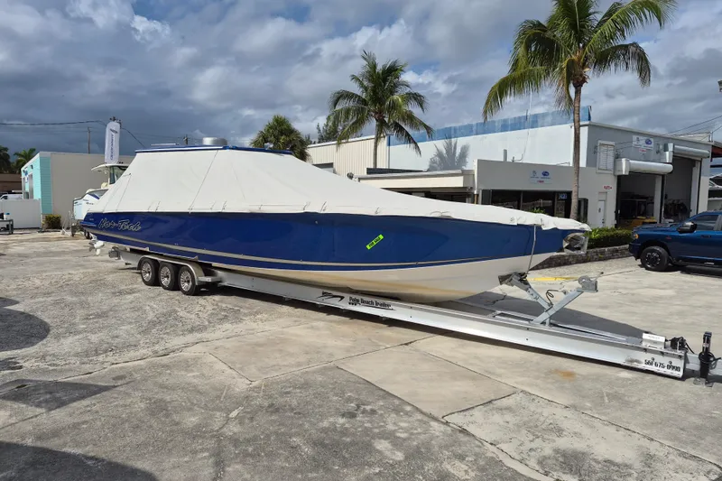Slide: The Image of 2020 Nor-Tech 450 Sport Center Console boat covered on trailer, parked outdoors. - 27
