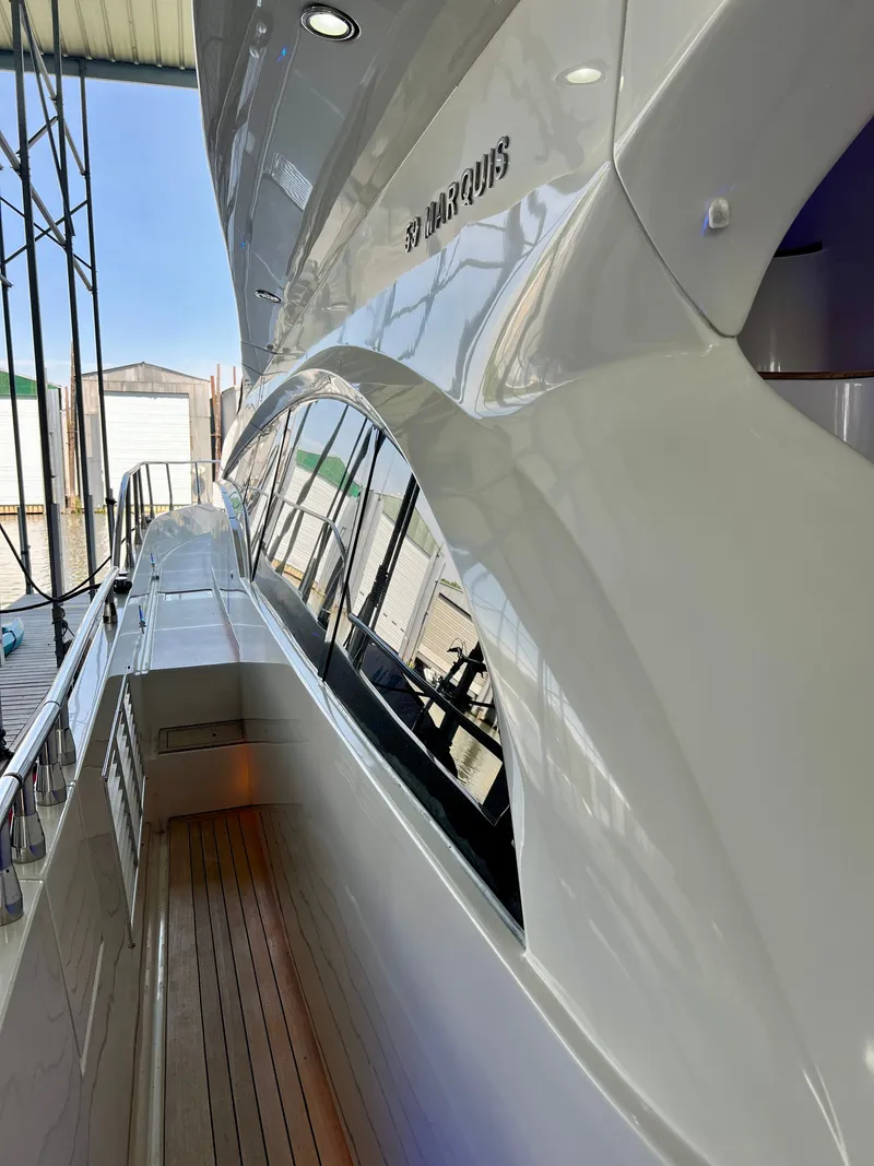 Slide: The Image of 2005 Marquis 59 yacht docked, featuring sleek white exterior. - 40