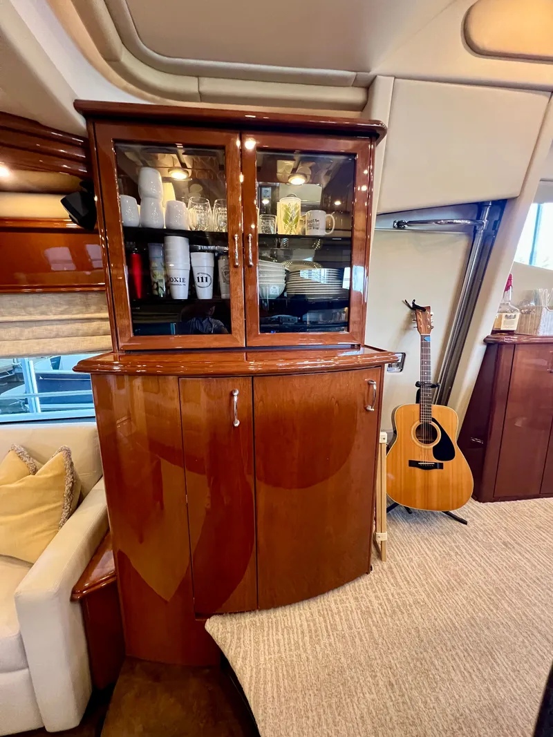 Slide: The Image of Luxurious interior of a 2005 Marquis 59 yacht with cabinet and guitar. - 8
