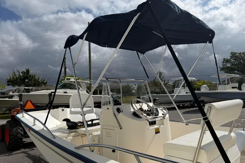 Slide: The Image of 2002 McKee Craft WayPoint boat with canopy, parked outdoors under cloudy skies. - 6