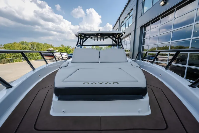 Slide: The Image of 2025 Navan S30 boat with sleek design, docked near modern building under cloudy sky. - 58
