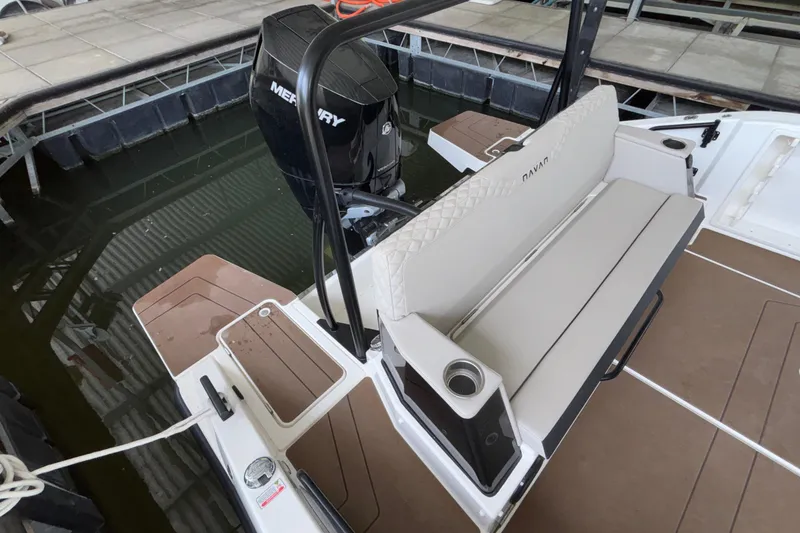 Slide: The Image of Navan S30 boat with Mercury engine, featuring cushioned seating and cup holders, docked in marina. - 72