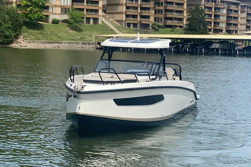 Slide: The Image of 2025 Navan S30 boat on a serene lake with modern architecture in the background. - 7