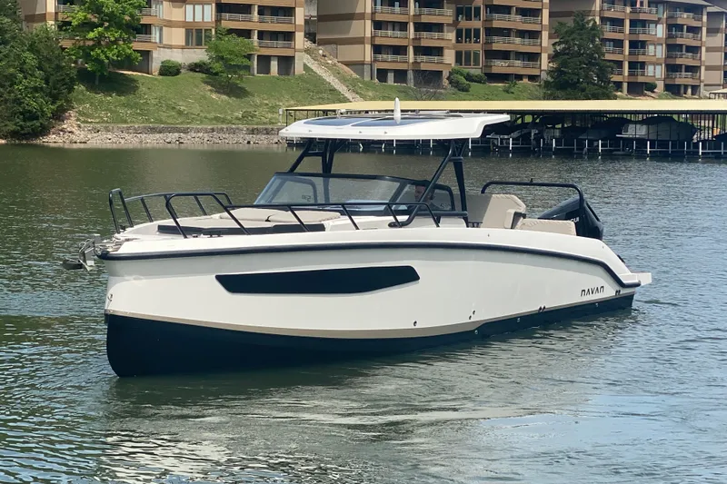 Slide: The Image of 2025 Navan S30 boat on a serene lake with modern architecture in the background. - 8