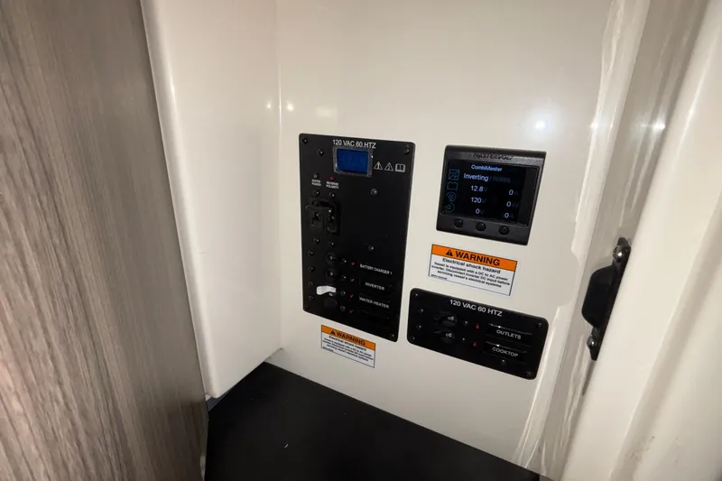 Slide: The Image of Electrical control panel in 2025 Navan S30, featuring inverter and warning labels. - 64