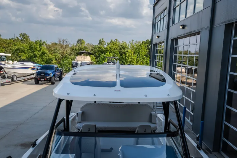 Slide: The Image of 2025 Navan S30 boat docked near modern building, surrounded by greenery and vehicles. - 59