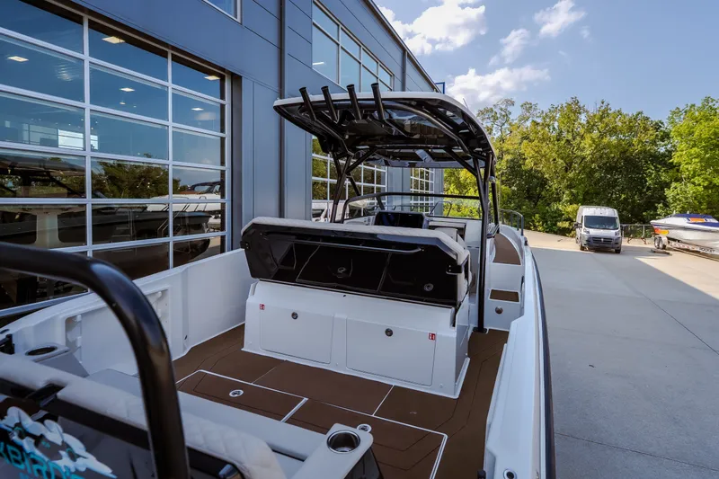 Slide: The Image of 2025 Navan S30 boat docked outside a modern building, showcasing sleek design and spacious deck. - 16