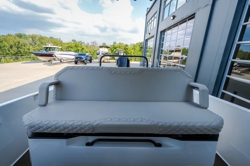 Slide: The Image of 2025 Navan S30 boat interior with cushioned seating, parked near other boats and vehicles. - 37