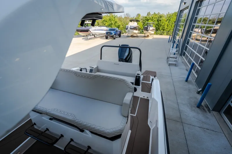 Slide: The Image of 2025 Navan S30 boat interior with seating, docked near a modern marina facility. - 60