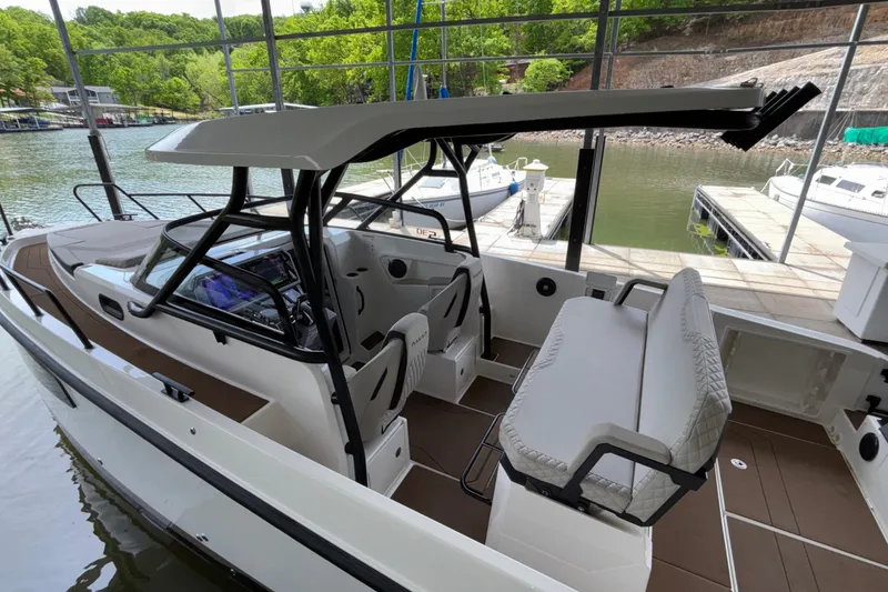 Slide: The Image of 2025 Navan S30 boat interior with modern seating and sleek design at a marina. - 12