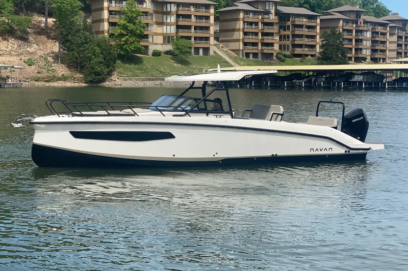The Image of Modern 2025 Navan S30 boat on a serene lake with waterfront buildings in the background. - 1