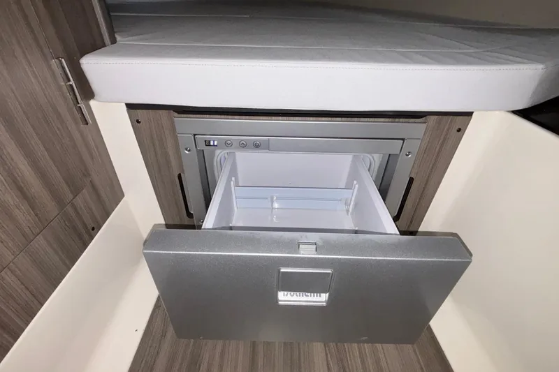 Slide: The Image of 2025 Navan S30 interior with open drawer refrigerator, wood paneling, and cushioned seating. - 67