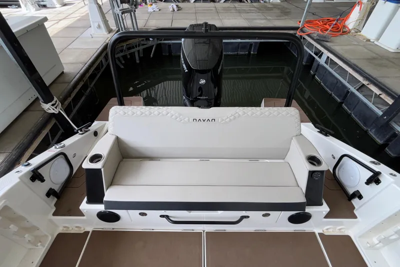 Slide: The Image of Navan S30 2025 boat interior with cushioned seating and cup holders at dock. - 17