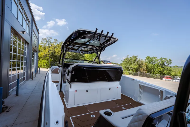 Slide: The Image of 2025 Navan S30 boat docked near a modern building, showcasing sleek design and spacious deck. - 18