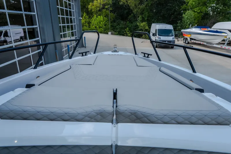 Slide: The Image of 2025 Navan S30 boat with cushioned deck, parked near a garage and other vehicles. - 55