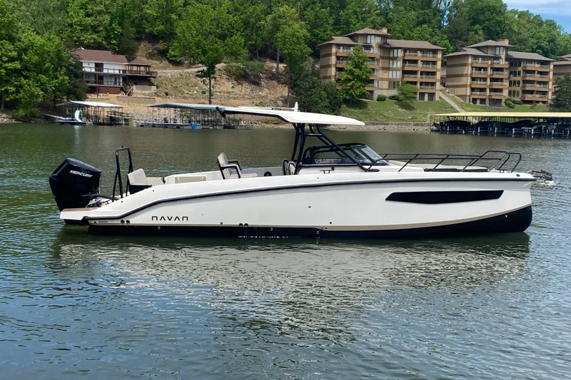 Slide: The Image of 2025 Navan S30 boat on a serene lake with lush greenery and buildings. - 5